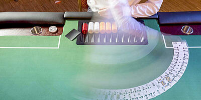 Dealer fächert Pokerkarten auf dem Pokertisch auf.