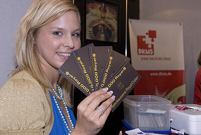 Spielgeldscheine für das Spielcasino der DKMS Frau hält Spielgeldscheine für ein mobiles Casino in der Hand.