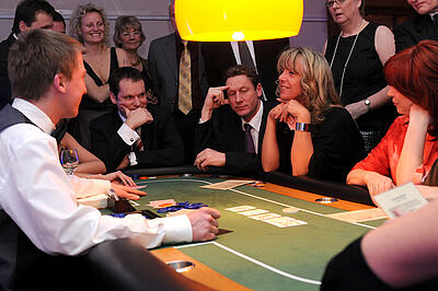 Poker als Idee für das Firmen-Sommerfest Gäste eines Firmen-Sommerfestes pokern.