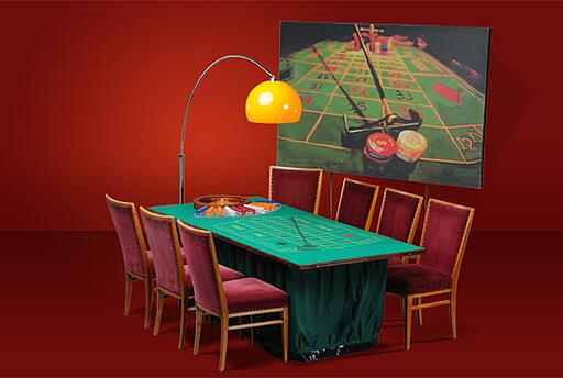 kleiner bestuhlter Roulette-Tisch vor einer Dekorationsstellwand kleiner bestuhlter Roulette-Tisch vor einer Dekorationsstellwand mit rotem Hintergrund