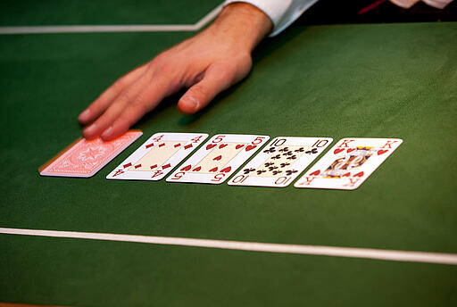 Poker bei der Casino Royal Weihnachtsfeier Dealer deckt fünfte Gemeinschaftskarte um.