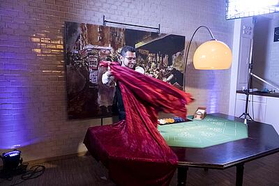 Croupier deckt Baccarat-Spieltisch ab Croupier deckt Baccarat-Spieltisch mit einem roten Tuch ab