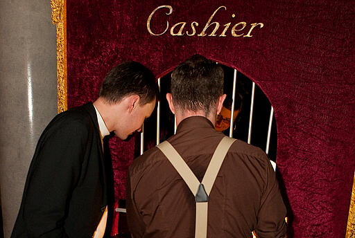 Kassenhaus bei der Weihnachtsfeier von brands4friends Zwei Gäste tauschen ihre Umtauschberechtigung am Kassenhaus gegen Jetons.