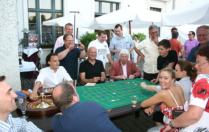 Gäste spielen ausgiebig Roulette bei einem Sommerfest.