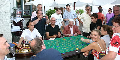 Gäste spielen ausgiebig Roulette bei einem Sommerfest.