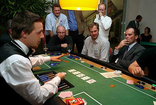 Poker-Tisch bei einem Come Together Messeevent der Makino Europe GmbH Dealer erklärt die Spielregeln beim Pokern.