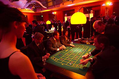 Roulettetisch bei eienr Kundenveranstaltung Gäste erklärenm sich gegenseitig Roulette bei einer Kundenveranstaltung.