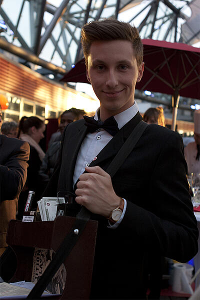 Bauchladenjunge als Idee für ein Corporate Event Lächelnder Bauchladenjunge beim Cine Royal im SonyCenter am Potsdamer Platz.