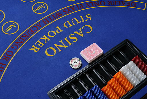 Tableau des Stud-Poker-Tischs mit Dealerbutton, Karten und Jetons Tableau des Stud-Poker-Spieltischs mit Dealerbutton, Spielkarten und Jetons