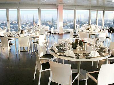 Innenansicht des Panoramadecks mit Aussicht über Hamburg Gedeckte Dinnertische im Panoramadeck mit Aussicht über Hamburg.