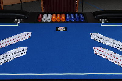 aufgefächerte Spielkarten auf großen Poker-Tisch aufgefächerte Spielkarten auf einem einsatzbereiten großen Poker-Tisch
