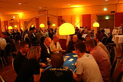 Pokerturnier mit einem Pokertisch mit Gästen im Vordergrund Pokerturnier mit einem Pokertisch mit Gästen im Vordergrund im Estrel Berlin