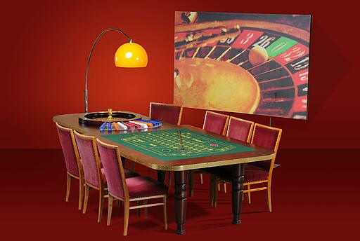 großer bestuhlter Roulette-Tisch vor einer Dekorationsstellwand großer bestuhlter Roulette-Tisch vor einer Dekorationsstellwand mit rotem Hintergrund