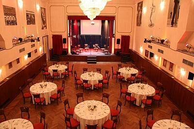 großer Saal mit runden Tischen im Queens 45c großer Saal mit runden Tischen, Bestuhlung und Bühne im Queens 45c