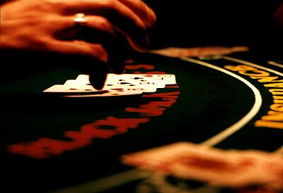 Hand über den Karten beim Blackjack Hand des Croupiers über seinen Karten beim Blackjack