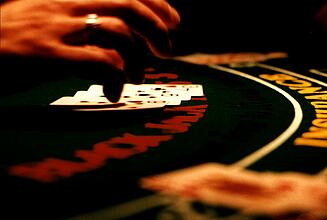 Hand über den Karten beim Blackjack Hand des Croupiers über seinen Karten beim Blackjack