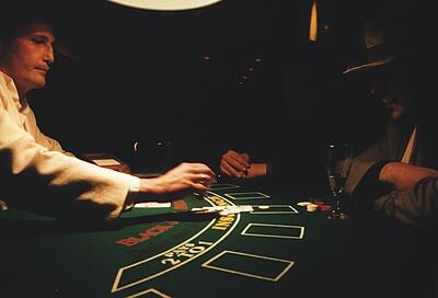 spielender Mann mit Hut am Blackjack-Tisch spielender Mann mit Hut am Blackjack-Tisch