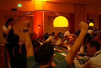 Spieler freut sich über Sieg beim pokern Spieler streckt die Arme nach oben und freut sich über Sieg beim pokern.