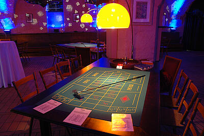 Roulette-Tisch beim Sommerfest der Deutschen Bank Einsatzbereiter Roulette-Tisch mit Casino-Projektionen im Raum bei einem Sommerfest der Deutschen Bank.